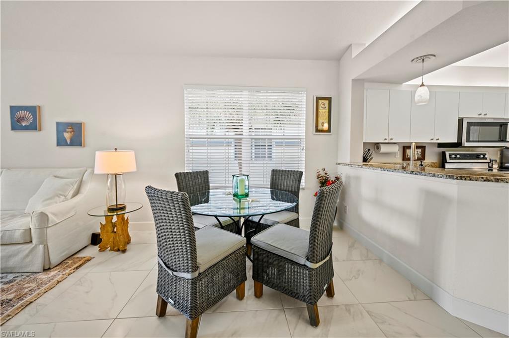 23741 Old Port Road, Unit 204 Estero, FL 34135 - Photo 10 of 46 a living room with furniture a flat screen tv and a window