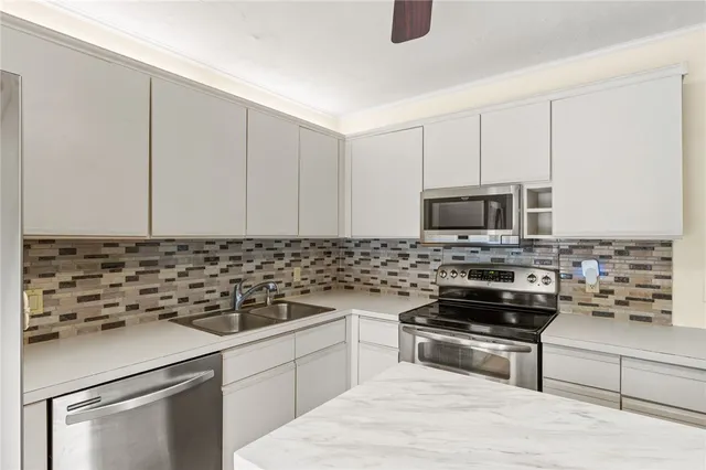 a kitchen with appliances a sink and cabinets