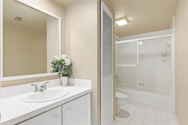 a bathroom with a granite countertop sink a toilet and shower