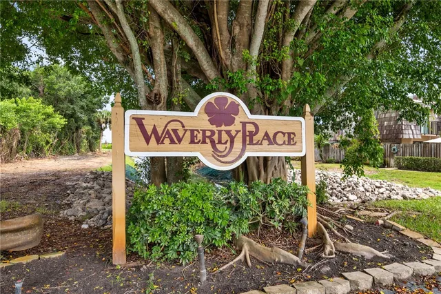 a view of a sign board with large trees