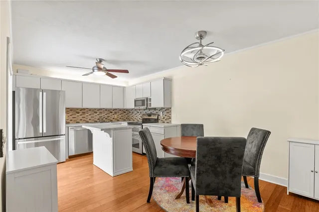 a kitchen with a dining table chairs stainless steel appliances and cabinets