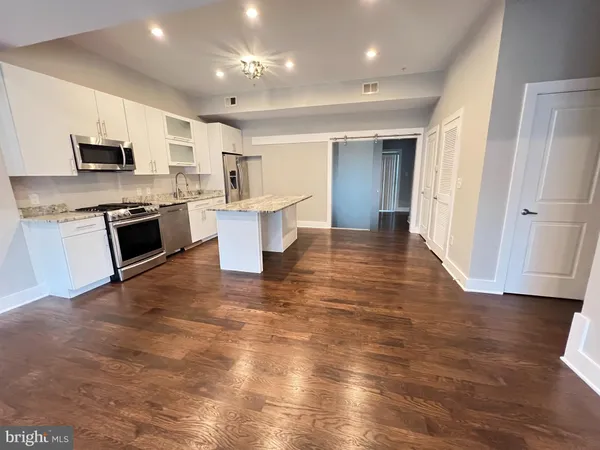 an open kitchen with white cabinets and stainless steel appliances
