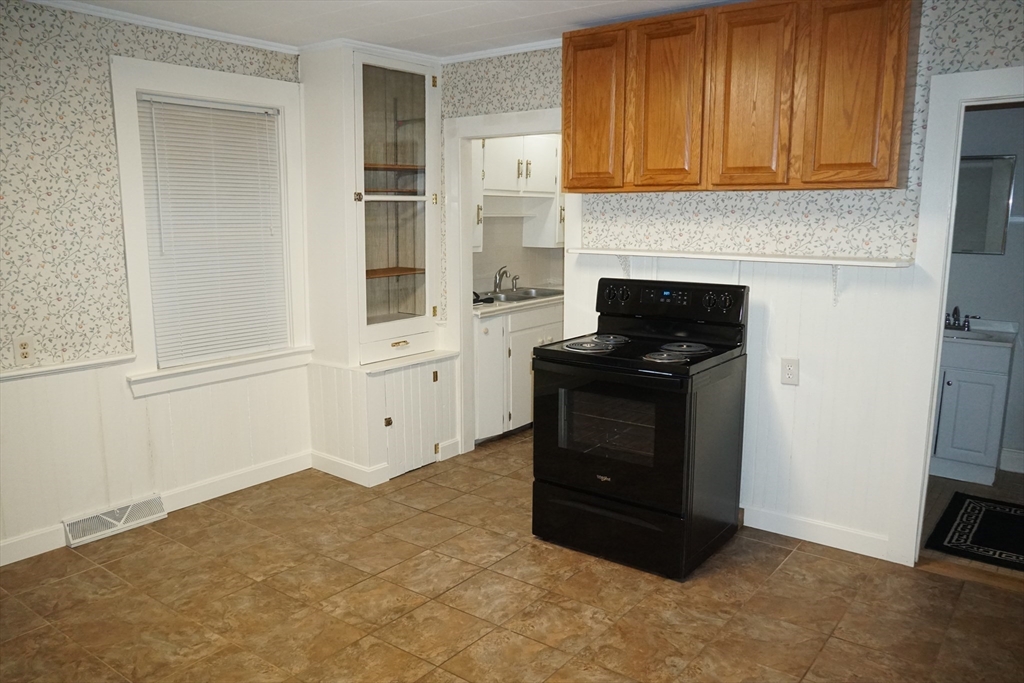 39 Burt Street, Unit 1 Berkley, MA 02779 - Photo 5 of 19 a kitchen with granite countertop white cabinets and refrigerator