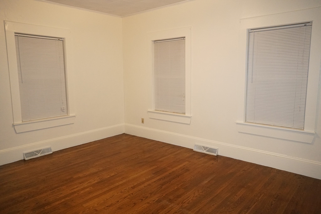 39 Burt Street, Unit 1 Berkley, MA 02779 - Photo 9 of 19 an empty room with wooden floor and windows