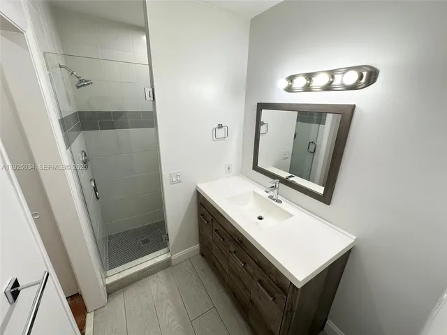 a bathroom with a sink a mirror and a shower