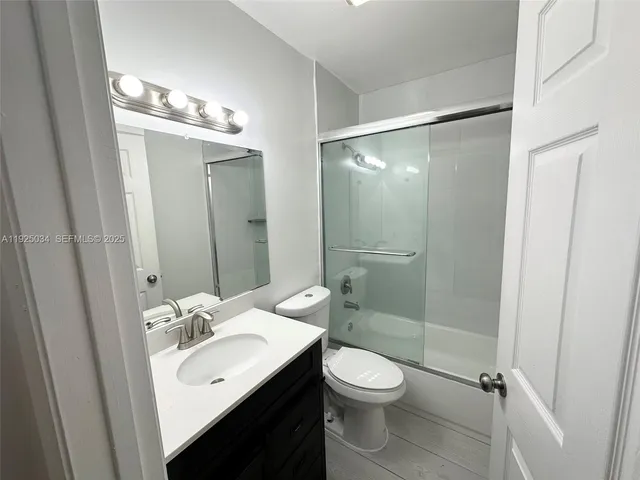 a bathroom with a sink toilet mirror and shower