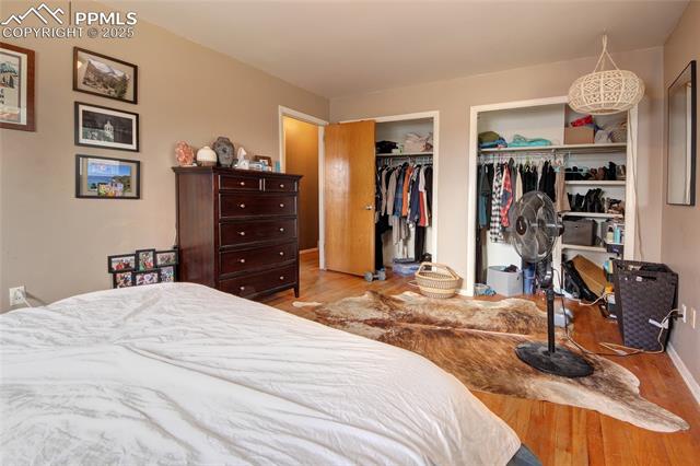 2415 Sturgis Road Colorado Springs, CO 80909 - Photo 9 of 10 Bedroom featuring wood finished floors and two closets
