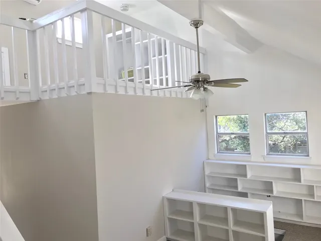 an empty room with a window and a fan