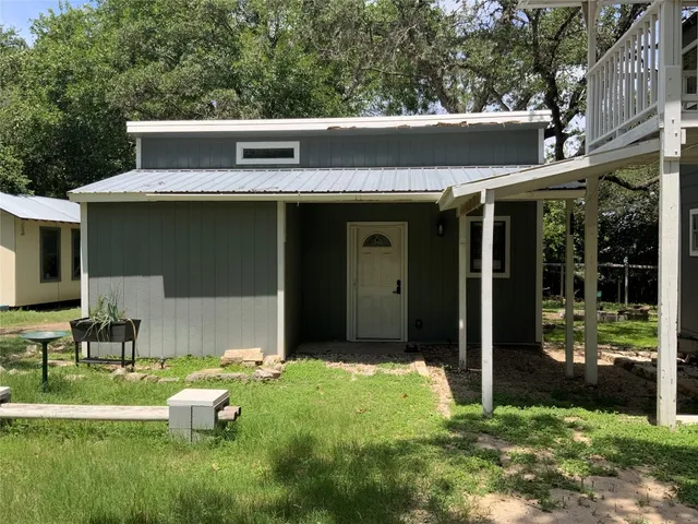 a view of a chair and table in backyard of the house