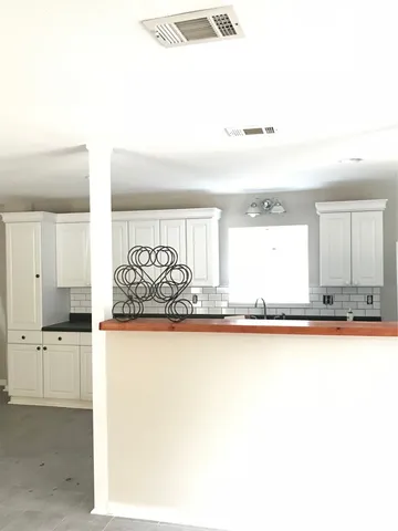 a view of a kitchen with kitchen island a sink and wooden floor