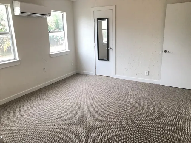a view of storage and utility room with window and wooden floors