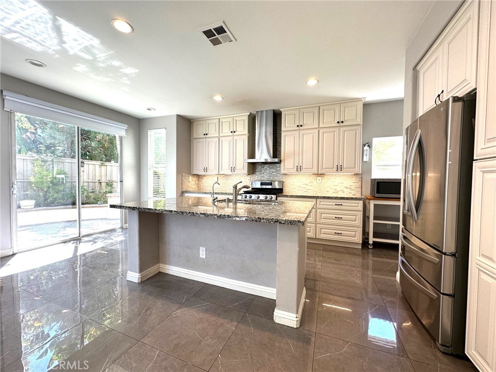 33 Sagebrush Irvine, CA 92618 - Photo 5 of 22 a kitchen with stainless steel appliances granite countertop a refrigerator a stove and a sink with cabinets