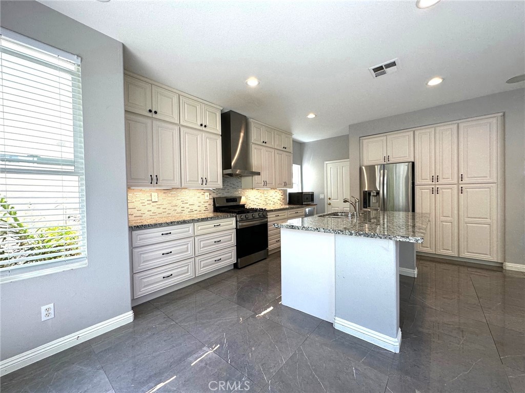 33 Sagebrush Irvine, CA 92618 - Photo 6 of 22 a kitchen with kitchen island a sink a stove a refrigerator cabinets and a window