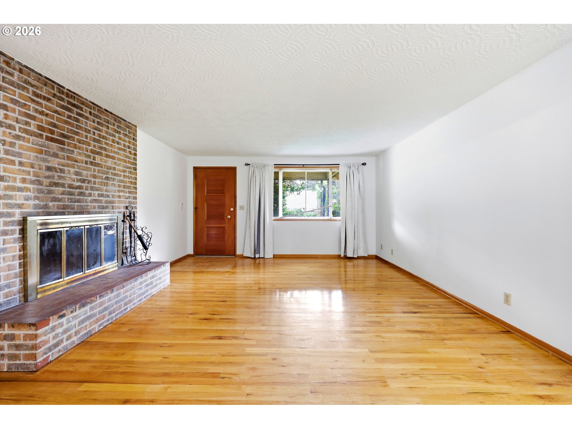 3003 Southeast 162nd Avenue Portland, OR 97236 - Photo 6 of 41 a view of empty room with wooden floor and fireplace