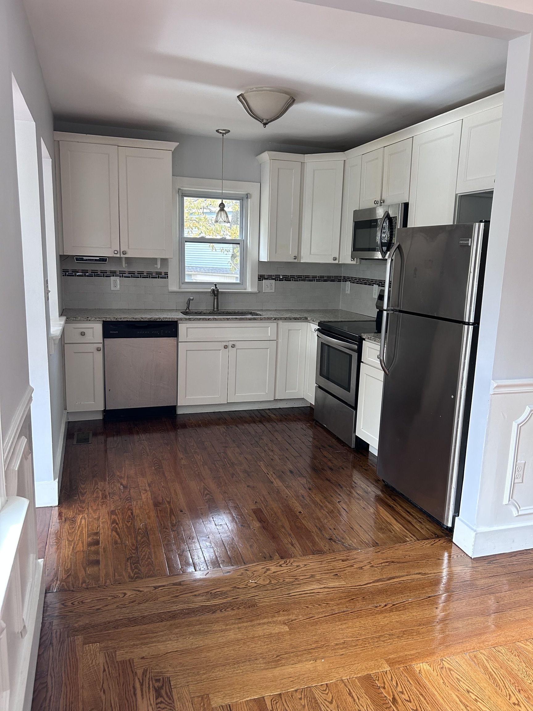 36 Forest Hills Road West Haven, CT 06516 - Photo 5 of 22 a kitchen with granite countertop a refrigerator oven a sink and white cabinets
