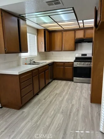 a large kitchen with stainless steel appliances granite countertop a stove and a sink