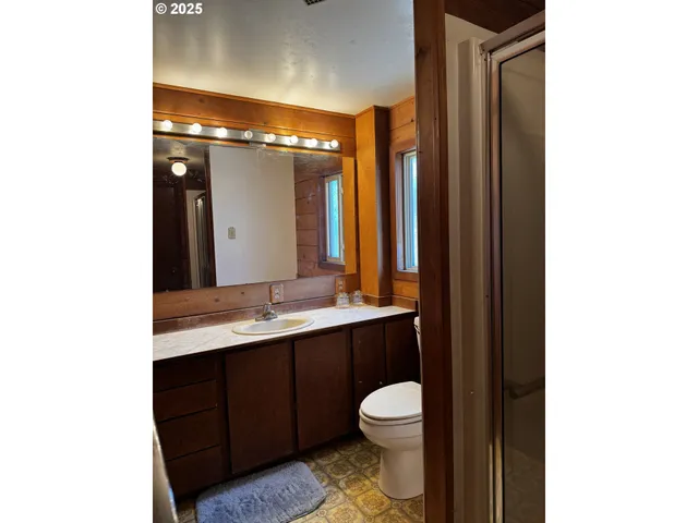 a bathroom with a sink a toilet a mirror and shower