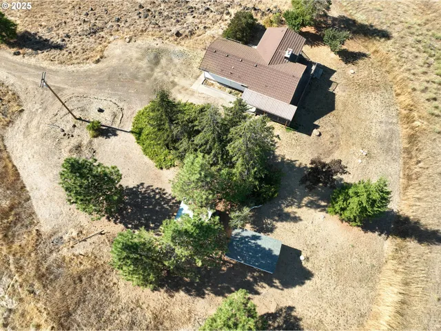 an aerial view of house with yard and mountain view in back