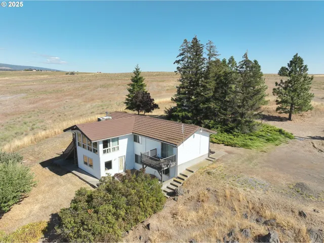 a aerial view of a house with a yard and ocean view