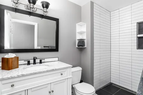 a bathroom with a toilet sink and mirror