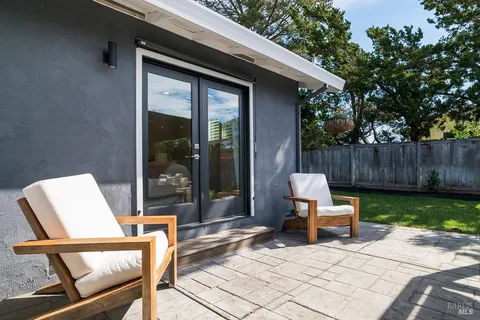 a view of backyard with table and chairs and wooden fence