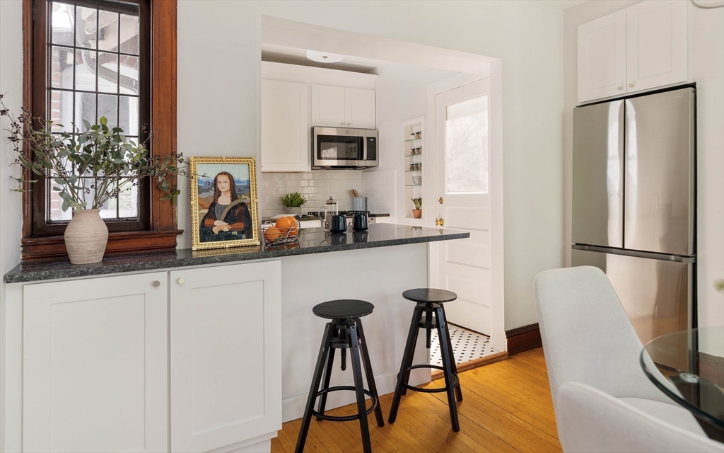 2 Clinton Street, Unit 37 Cambridge, MA 02139 - Photo 11 of 23 a kitchen with stainless steel appliances granite countertop a refrigerator a sink a stove and white cabinets