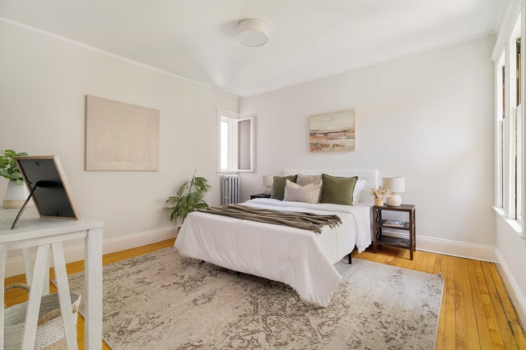 2 Clinton Street, Unit 37 Cambridge, MA 02139 - Photo 14 of 23 a spacious bedroom with a bed and a dresser next to a window