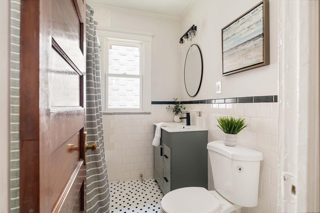 2 Clinton Street, Unit 37 Cambridge, MA 02139 - Photo 20 of 23 a bathroom with a sink mirror vanity and toilet