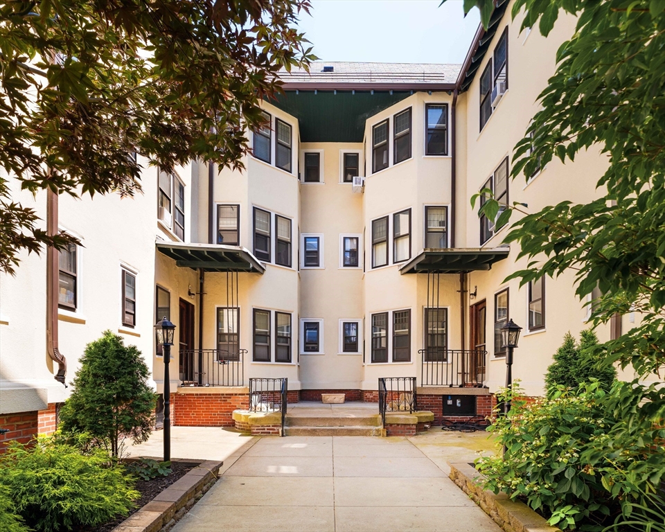 2 Clinton Street, Unit 37 Cambridge, MA 02139 - Photo 22 of 23 a view of a white building among the street with palm trees