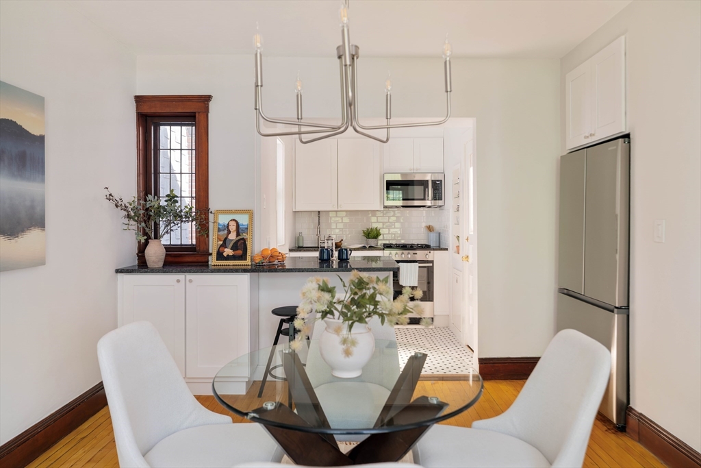 2 Clinton Street, Unit 37 Cambridge, MA 02139 - Photo 8 of 23 a kitchen with stainless steel appliances granite countertop a dining table chairs and a refrigerator