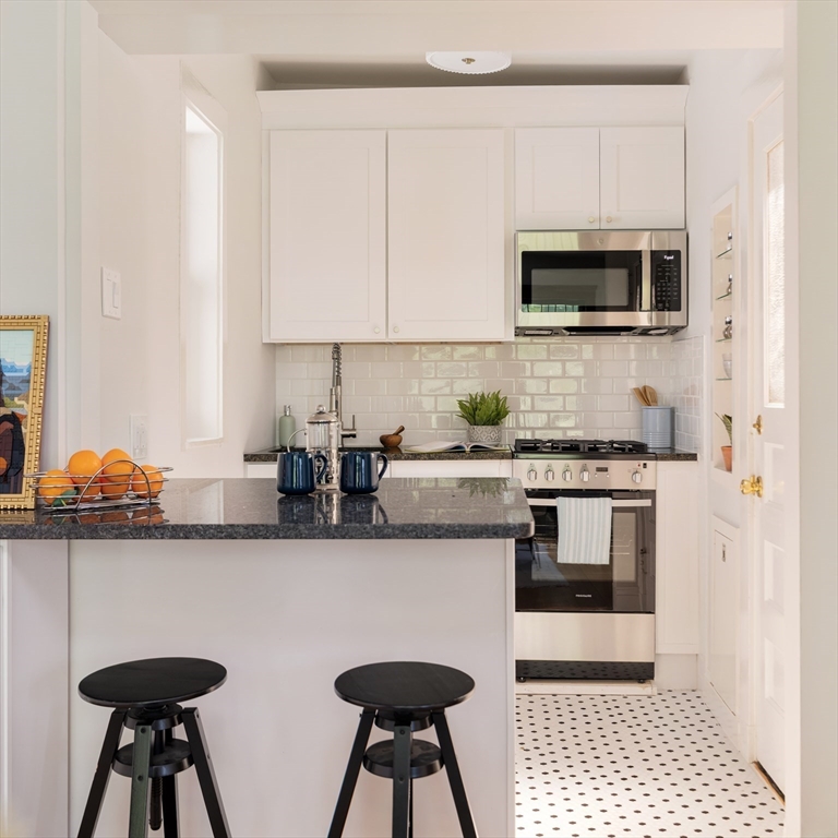 2 Clinton Street, Unit 37 Cambridge, MA 02139 - Photo 9 of 23 a kitchen with stainless steel appliances a sink a stove a microwave cabinets and a counter top space