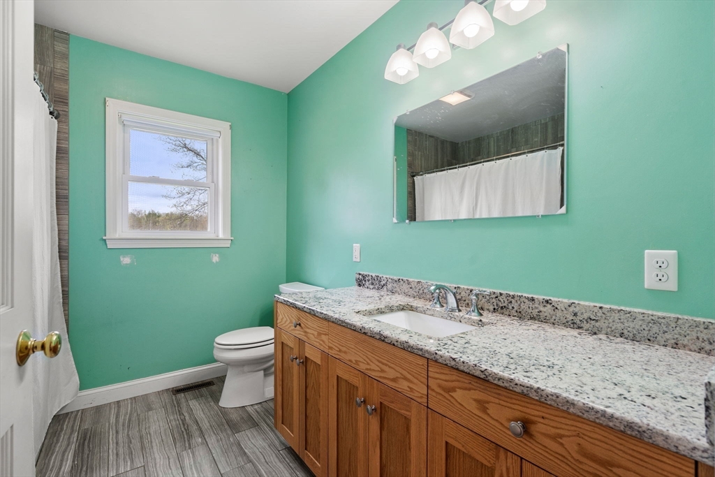 3 Brown Road Townsend, MA 01469 - Photo 19 of 41 a bathroom with a granite countertop toilet sink and mirror