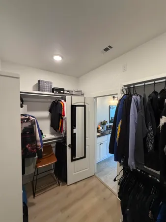 a view of walk in closet with clothes and shoes