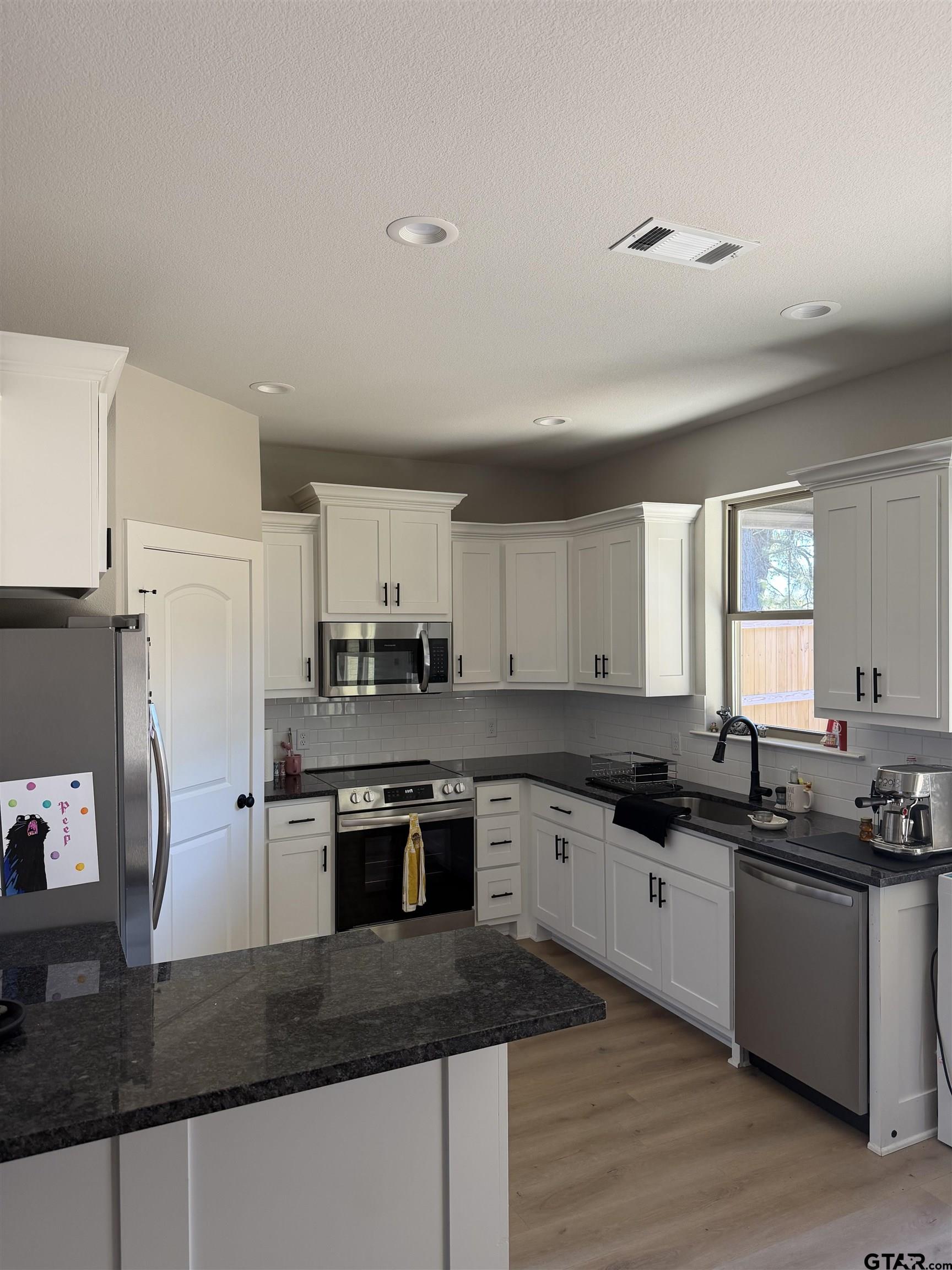11201 County Road 166 Tyler, TX 75703 - Photo 5 of 19 a kitchen with granite countertop a sink a counter top space cabinets and stainless steel appliances
