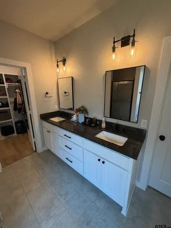 a spacious bathroom with a double vanity sink and mirror