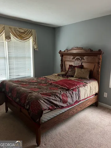 a bedroom with a bed and a large window