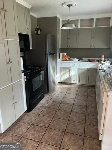 a kitchen with granite countertop a refrigerator and a stove top oven