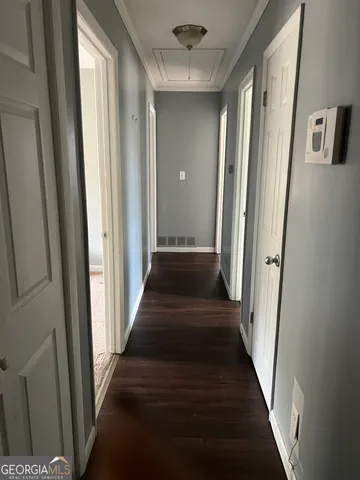 a view of a hallway with wooden floor and staircase