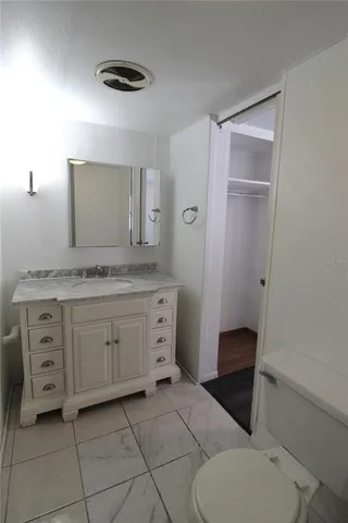 a spacious bathroom with a granite countertop sink toilet and mirror