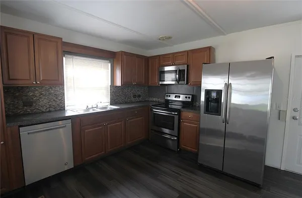 a kitchen with a refrigerator and a sink