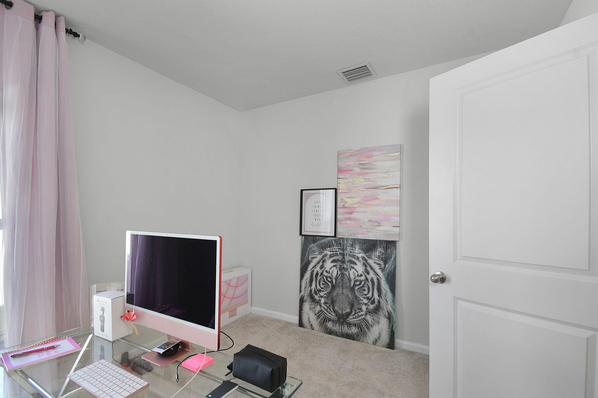 113 Dabou Loop Belle Glade, FL 33430 - Photo 16 of 22 a bedroom with a bed and a flat screen tv