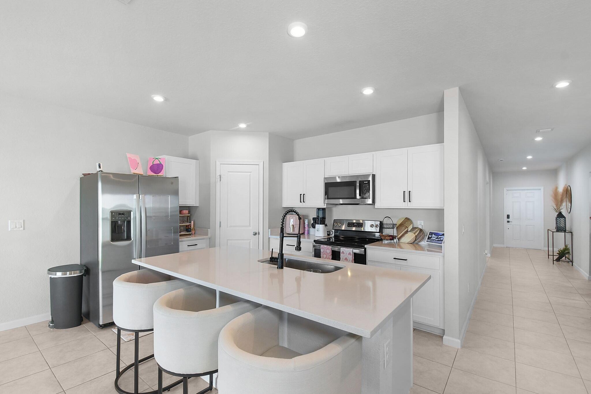 113 Dabou Loop Belle Glade, FL 33430 - Photo 4 of 22 a kitchen with stainless steel appliances a sink and a refrigerator