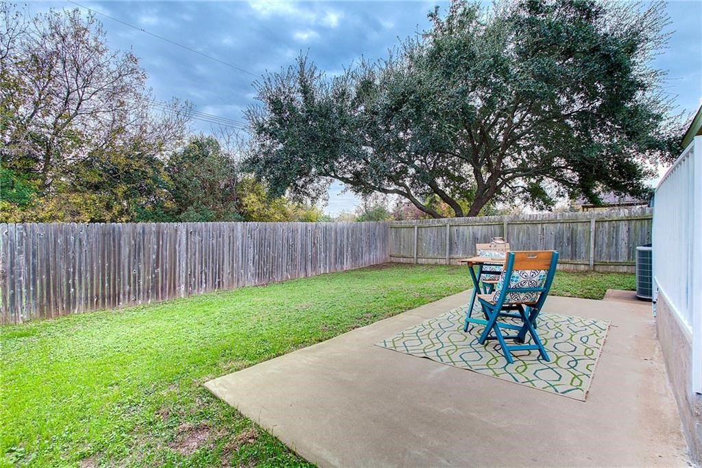 7107 Alegre Pass Austin, TX 78744 - Photo 18 of 20 a view of a backyard with table and chairs and wooden fence