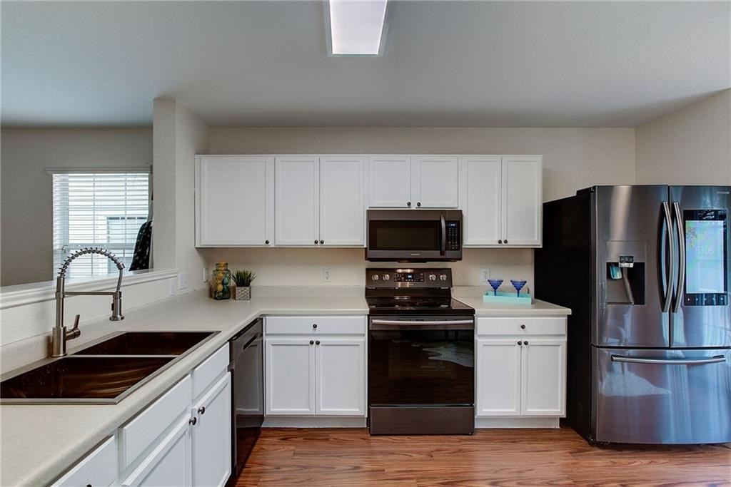 7107 Alegre Pass Austin, TX 78744 - Photo 7 of 20 a kitchen with appliances a sink and cabinets
