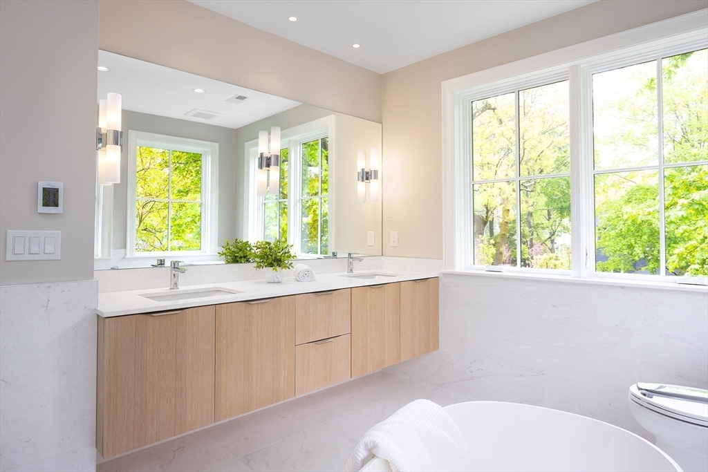 15 Woodcliff Road Newton, MA 02461 - Photo 15 of 27 a bathroom with a granite countertop toilet a sink and a large mirror