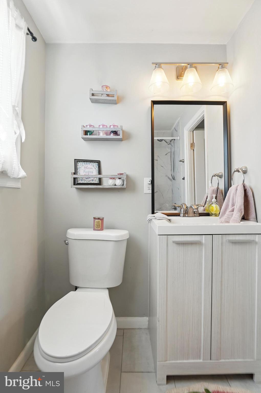7812 Jamesford Road Dundalk, MD 21222 - Photo 30 of 30 a bathroom with a toilet a sink and mirror