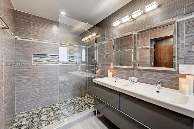 a bathroom with a sink mirror and shower