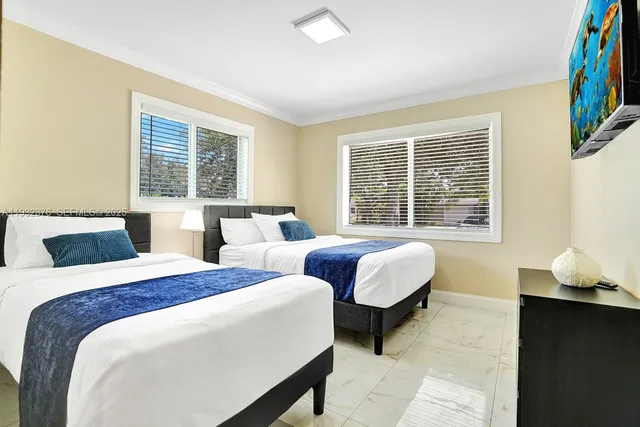 a bedroom with two beds and a window