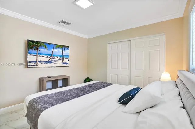 a bedroom with a large bed and a chandelier