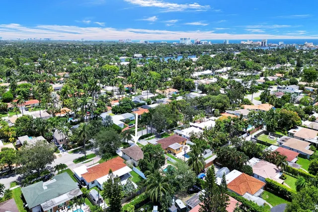 an aerial view of residential houses with outdoor space and trees